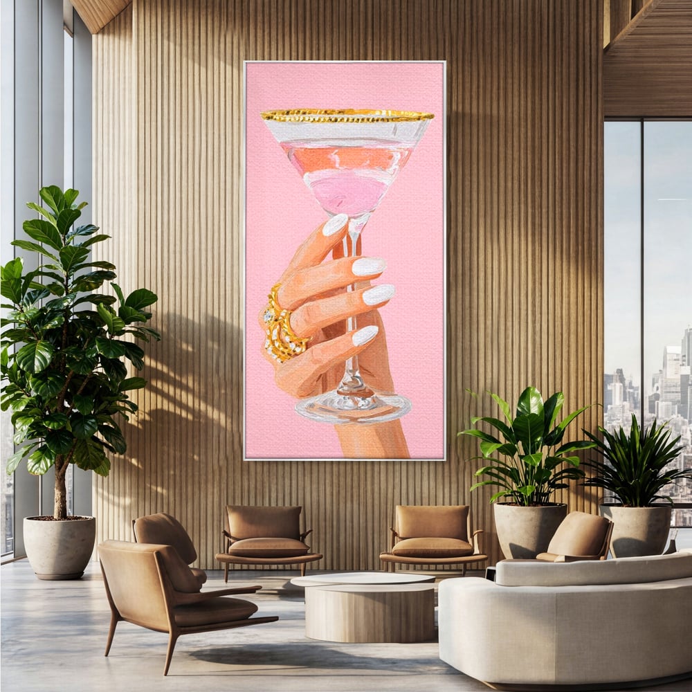 Tablou canvas cu ilustratie cu mana care tine pahar de cocktail, in rama de aluminiu argintiu, pe perete intr-un birou